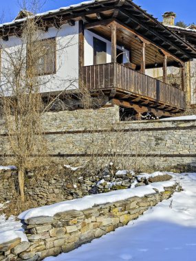 Bulgaristan 'ın Blagoevgrad Bölgesi, Otantik 19. yüzyıl evleriyle Kovaçevitsa Köyü Kış Günbatımı manzarası