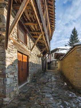 Bulgaristan 'ın Blagoevgrad Bölgesi, Otantik 19. yüzyıl evleriyle Kovaçevitsa Köyü Kış Günbatımı manzarası