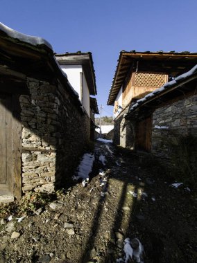 Bulgaristan 'ın Blagoevgrad Bölgesi, Otantik 19. yüzyıl evleriyle Kovaçevitsa Köyü Kış Günbatımı manzarası