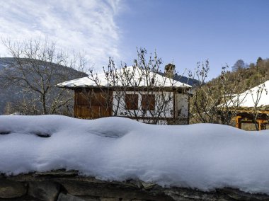 Bulgaristan 'ın Blagoevgrad Bölgesi, Otantik 19. yüzyıl evleriyle Kovaçevitsa Köyü Kış Günbatımı manzarası