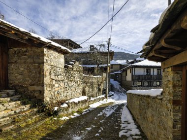 Bulgaristan 'ın Blagoevgrad Bölgesi, Otantik 19. yüzyıl evleriyle Kovaçevitsa Köyü Kış Günbatımı manzarası