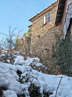 Bulgaristan 'ın Blagoevgrad Bölgesi, Otantik 19. yüzyıl evleriyle Kovaçevitsa Köyü' nün kış manzarası