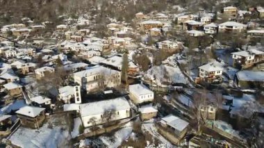 Bulgaristan 'ın Blagoevgrad Bölgesi, Otantik 19. yüzyıl evleriyle Kovaçevitsa Köyü' nün Hava Kış Günbatımı manzarası