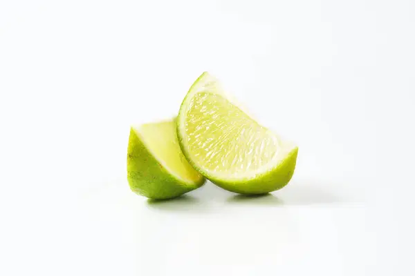 Két Lime Gyümölcs Negyedek Fehér Alapon Stock Kép