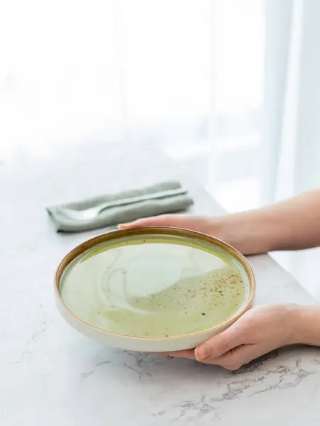 Pencerenin Önündeki Beyaz Mermer Masada Boş Yeşil Tabak Tutan Elleri — Stok fotoğraf