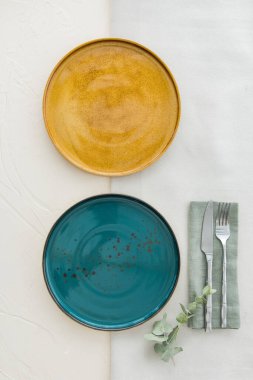 Masada iki boş tabak ve çatal bıçak takımı var. Yukarıdan bak. Masadaki iki seramik tabağın üst görüntüsü. Düz yatıyordu