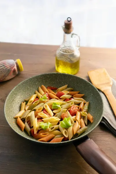 Deliciously Prepared Colorful Pasta Dish Sits Green Pan Surrounded Bottle Royalty Free Stock Photos