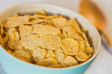 Mavi kasede gevrek şekersiz mısır gevrekleri, doğal ışıkla fotoğraflanmış (Seçici Odaklanma, üçte birini kaseye odakla)