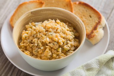 Taze ev yapımı vejetaryen yemeği veya kırmızı mercimek, soğan, sarımsak ve maydanozla yapılan salata, tabakta kızarmış ekmek ile servis edilir (Seçici Odaklanma, üçte birini mercimeklere odakla)