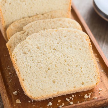 Ekmek yapma makinesi tarafından yapılan taze ev yapımı beyaz ekmek dilimleri, ahşap tahtada servis edilir (Seçici Odaklanma, görüntünün ortasında odaklan)