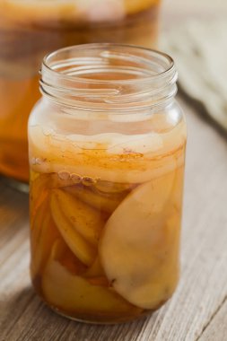 Homemade black tea kombucha or tea mushroom in glass jar with lots of scoby, a healthy fermented probiotic drink, on wooden table (Selective Focus, Focus on the front of the top scoby) clipart