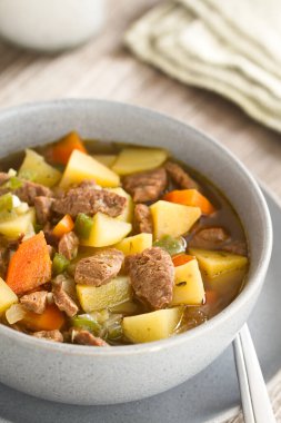 Sebze patatesi, soğan, sarımsak, havuç, yeşil biber ve soya et parçacıkları ile yapılan vejetaryen çorbası veya güveç, kasede servis edilir (Seçici Odak, yemeğin üçte birine odaklan)