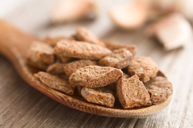 Dehydrated chunks of soy meat or texturized vegetable protein on wooden spoon, garlic cloves in the back (Selective Focus, Focus one third into the spoon)  clipart