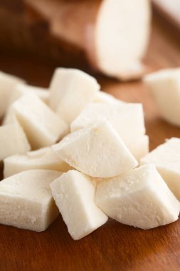 Taze kesilmiş manyok, manyok veya yuca (lat. Tahta üzerinde (Seçici Odaklanma, görüntünün ortasındaki parçaya odaklan) Manihot esculenta)