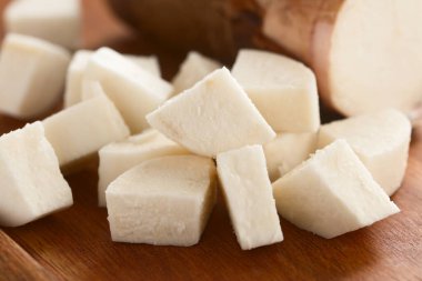 Taze kesilmiş manyok, manyok veya yuca (lat. Tahta üzerinde (Seçici Odaklanma, görüntünün ortasındaki parçaya odaklan) Manihot esculenta)