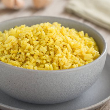 Ev yapımı sarı pirinç tabağı, zerdeçal, soğan, sarımsak, tuz, biber ve kişniş ile pişirilmiş, kasede servis edilmiş (Seçici Odak, görüntünün ortasında odaklan)