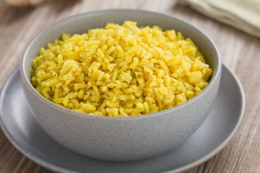 Ev yapımı sarı pirinç tabağı, zerdeçal, soğan, sarımsak, tuz, biber ve kişniş ile pişirilmiş, kasede servis edilmiş (Seçici Odak, görüntünün ortasında odaklan)