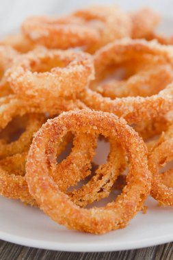 Bir tabakta ev yapımı kızarmış soğan halkaları (Seçici Odaklanma, ön taraftaki soğan halkasının üst kısmına odaklan)