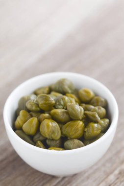 Arkasında kopya alanı olan küçük bir kasede turşulu kapari (Seçici Odaklanma, görüntünün üçte birine odaklan)