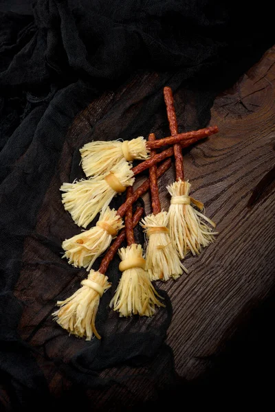 stock image Witches Broom of smoked cheese suluguni and salami. Original idea Halloween snack.