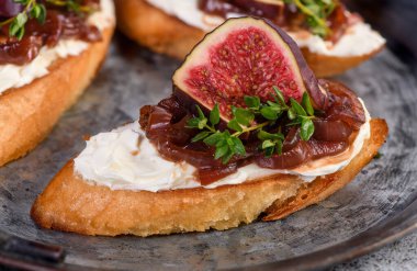 Kanepe veya kızarmış baget, krem peynir, soğan reçeli, incir ve teneke tepside taze kekik. Aperatif olarak ideal aperatif..