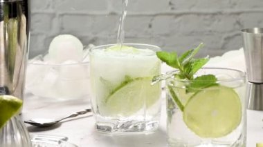 Naneli mojito mükemmel bir alkolsüz tariftir. Buzlu, limonlu ve naneli bir bardak tonikle doludur. Yakın plan. Bu bir dizi dikey videonun bir parçası. Süper yavaş çekim