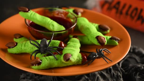 令人毛骨悚然的 可怕的巫婆的手指由糖绿色饼干与覆盆子果酱和杏仁万圣节 不给糖就捣蛋慢动作 在一个圆圈里四 后续行动 — 图库视频影像