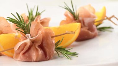 Kurutulmuş domates ve mozzarella ile doldurulmuş pastırma paketleri. Kutlama yemeğinde sunulan yaratıcı bir aperatif.