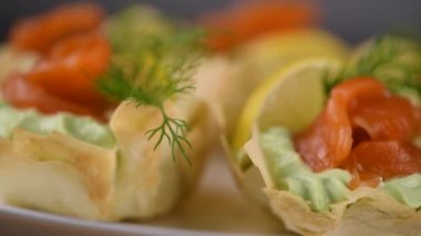 Yumuşak peynirli kremayla çırpılmış avokado en leziz krema, bir dilim somon ve limon. Fırında pilav hamuruyla çıtır çıtır sepetlerde servis ediliyor. Tatil menüsü için mükemmel bir aperatif.