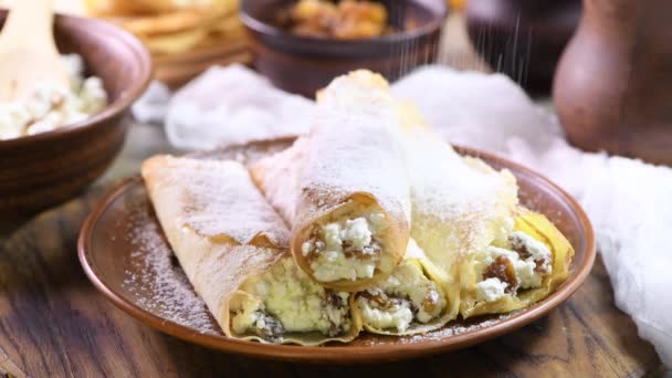 薄薄的薄饼 里面塞满了奶酪 蜂蜜和葡萄干 卷成管状 撒满了糖粉 用薄荷装饰 一系列视频食谱中的一部分 异教徒假日的节日菜肴Maslenitsa — 图库视频影像