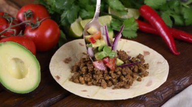 Kıymalı taco, avokado sosu, lahana ve peynir hazırla. Meksika mutfağı. Yakın plan. Gerçek zamanlı.