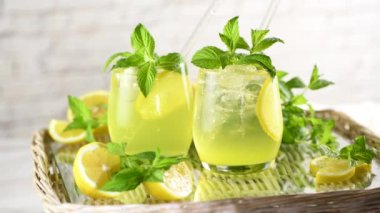 Naneli limoncello Spritz hafif, ferahlatıcı, tepside soğuk bir kokteyl. Yavaş çekim videosu. Soldan sağa daire şeklinde hareket.