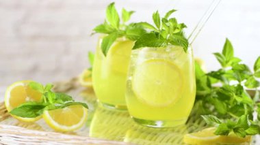 Naneli limoncello Spritz hafif, ferahlatıcı, tepside soğuk bir kokteyl. Yavaş çekim videosu. Sağdan sola bir çember içinde hareket. 