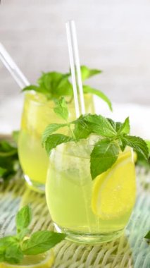 Limoncello Spritz hafif, ferahlatıcı, limon likörü, sucuk ve köpüklü su, nane ve limondan yapılan soğuk bir kokteyl. Dikey, yavaş çekim videosu. Soldan sağa daire şeklinde hareket