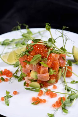 Avokado tartar, somon, kırmızı havyar ve bezelye filizi..