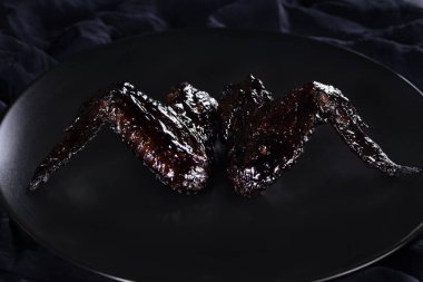  Vampir Kanatları (Tavuk Kanatları) mürekkepbalığıyla tatlı ve ekşi sosta pişirildi. Cadılar Bayramı partisi için orijinal bir fikir.