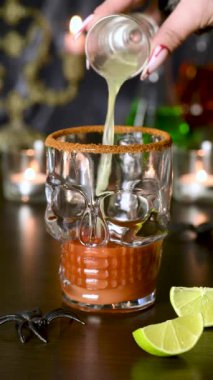 Michelada Kokteyli, Bloody Mary. Meksika içeceği domates suyu, limon suyu, sos ve bira, kereviz sapı, limon, zeytin ile süslenmiş. Cadılar Bayramı partisi fikirleri. Dikey video