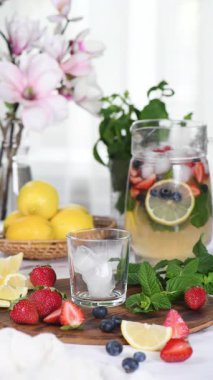 Çilekli, böğürtlenli ve naneli Summer Limonade yapıyorum. Gerçek zamanlı dikey video. Yakın plan.