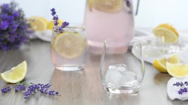 Bardağı taze ev yapımı lavanta limonatasıyla dolduruyorum. Yatay video. Gerçek zamanlı. Yakın plan.