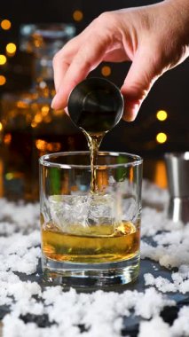 Kış viskisi, eski moda kokteyl hazırlıyorum. Baharatlı biberiye, sıcak burbon, taze limon ve portakalla karıştırılmış şurup. Serin akşamlar için mükemmel. Dikey video. Gerçek zamanlı.