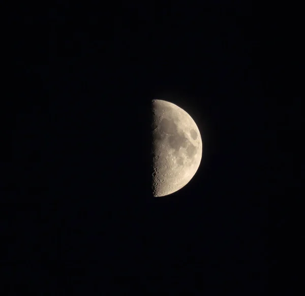 月の半分は夜空にクレーターがあります 第1四半期の瞬間の月の円盤 望遠鏡のズームビュー ストックフォト