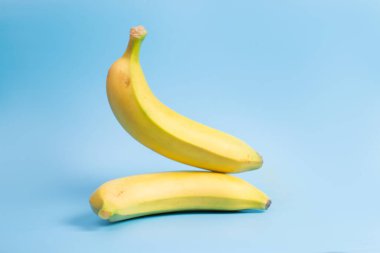 Muz havalanması. Mavi arka planda iki sarı muz.