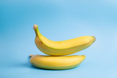 Mavi arka planda iki muz. Minimalist yiyecekler.