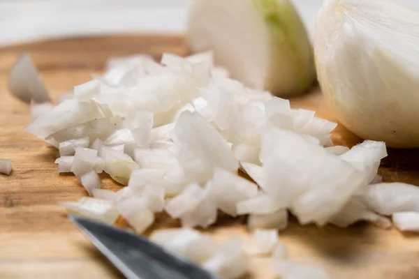 Diced onion on a wooden cutting board. Sliced white onion.