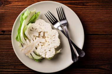 A piece of cauliflower close-up on a plate. Vegetarian concept, healthy eating.