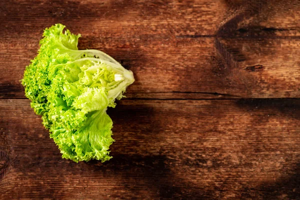 Ahşap arka planda yeşil marul salatası. Vejetaryenlik konsepti, bitki gıdası. Metin için yer.
