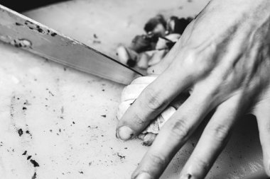 Kesme tahtasında dilimlenmiş şampiyon mantarları. Kadınların elleri bıçakla mantar kesiyor..