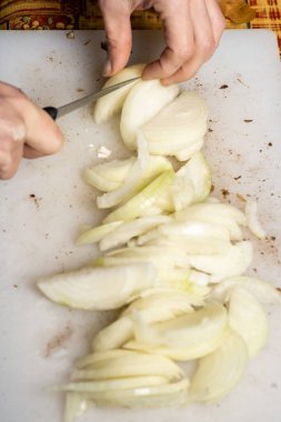Kesme tahtasında dilimlenmiş beyaz soğan. Yemek için malzemeler hazırlanıyor.