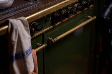 Old fashioned gas stove dark green. Part of home cooking.