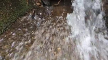Stormy water flow of a stream from a pipe close-up.